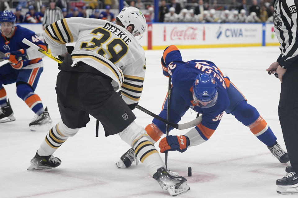 Boston Bruins center Morgan Geekie (39) and New York Islanders center Kyle MacLean (32) face off during the second period of an NHL hockey game in Elmont, N.Y., Saturday, March 2, 2024. (AP Photo/Peter K. Afriyie)