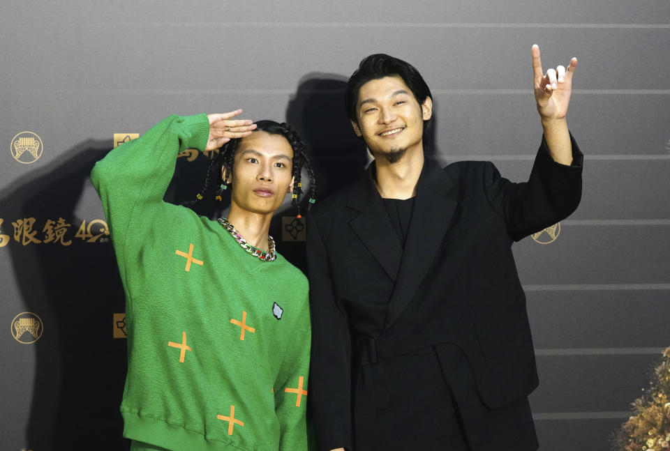 Taiwanese singer Leo Wang, right, of pop musical group "Yeemao" poses on arrival at the 31th Golden Melody Awards in Taipei, Taiwan, Saturday, Oct. 3, 2020. The awards show, one of the world's biggest Chinese-language pop music annual events was postponed from June to Oct. due to the coronavirus pandemic. (AP Photo/Billy Dai)