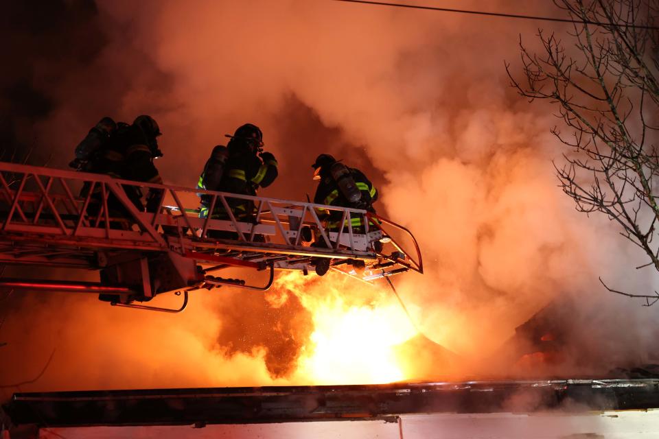 Firefighters from numerous communities battle a two-alarm house fire at 306 Washington St. in Abington on Sunday, Feb. 5, 2023.