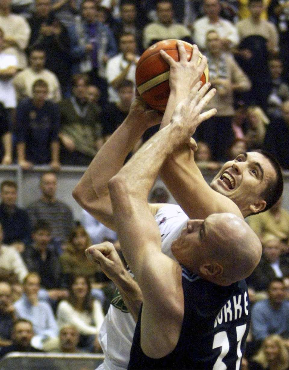 FILE - Real Madris's Patrick Burke, front, challenges Dejan Milojevic, of Partizan Pivara MB, for the ball during their Euroleague, group A, third round basketball match in Belgrade, Thursday, Nov. 18, 2004. Golden State Warriors assistant coach Dejan Milojević, a mentor to two-time NBA MVP Nikola Jokic and a former star player in his native Serbia, died Wednesday, Jan. 17, 2024, after suffering a heart attack, the team announced. Milojević, part of the staff that helped the Warriors win the 2022 NBA championship, was 46.(AP Photo/Darko Vojinovic, File)