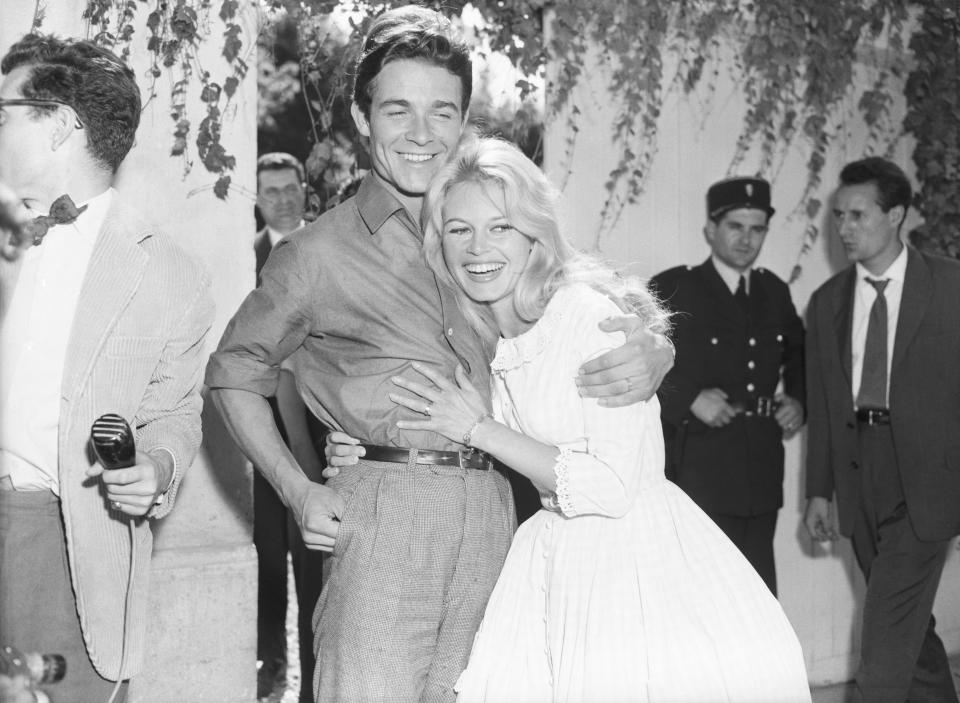 Brigitte Bardot hugs husband Jacques Charrier as the two grin.