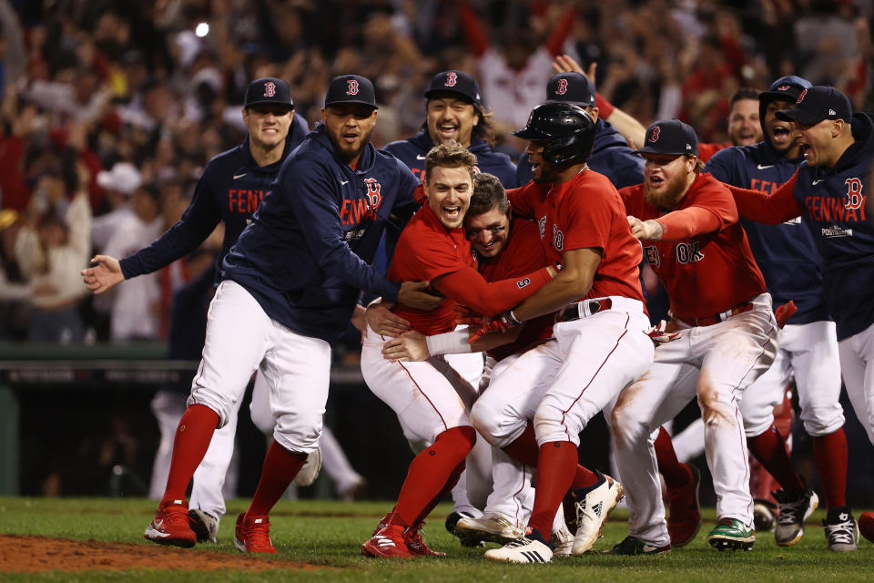 The Red Sox celebrate at home plate after walking off with a Game 4 win to eliminate the Rays and advance to the ALCS.