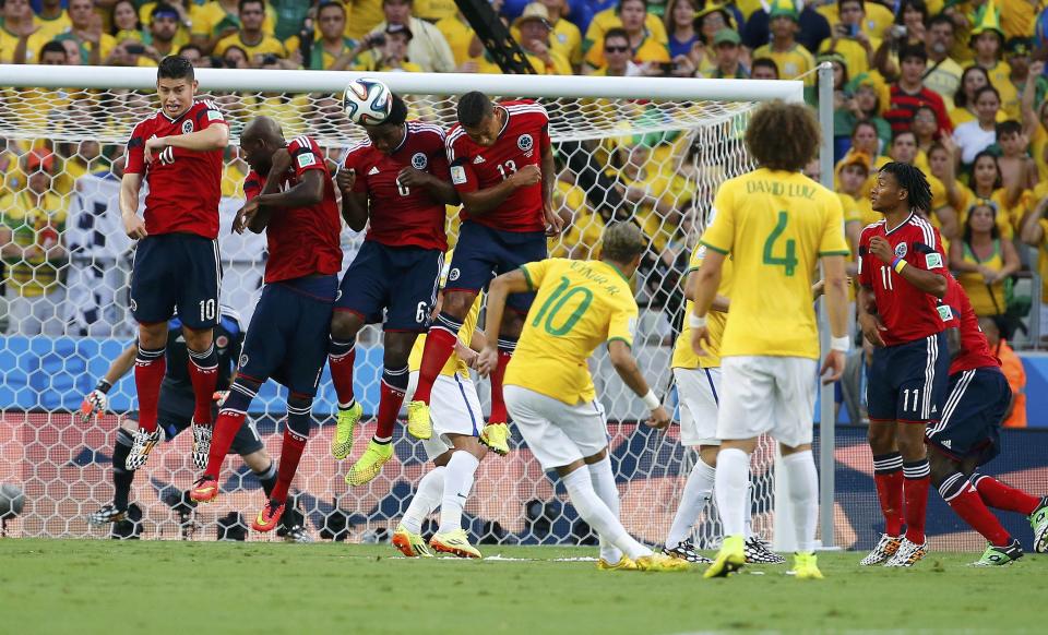 Brazil's Neymar (C) takes a free kick against Colombia during the 2014 World Cup quarter-finals soccer match at the Castelao arena in Fortaleza July 4, 2014. REUTERS/Yves Herman