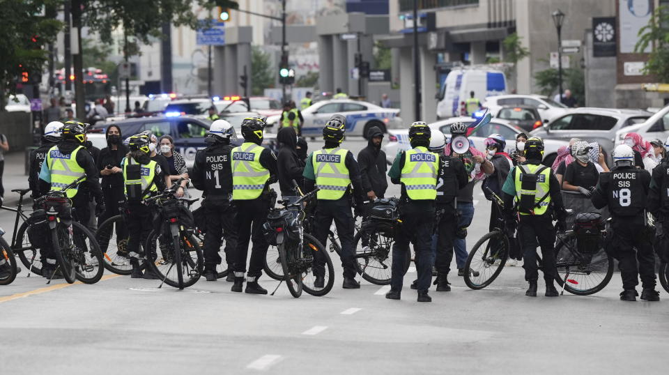 Pro-Palestinian supporters protest in front of police as they cordon off the block around McGill university while school security begins to dismantle their encampment in Montreal, Wednesday, July 10, 2024. (Christinne Muschi/The Canadian Press via AP)