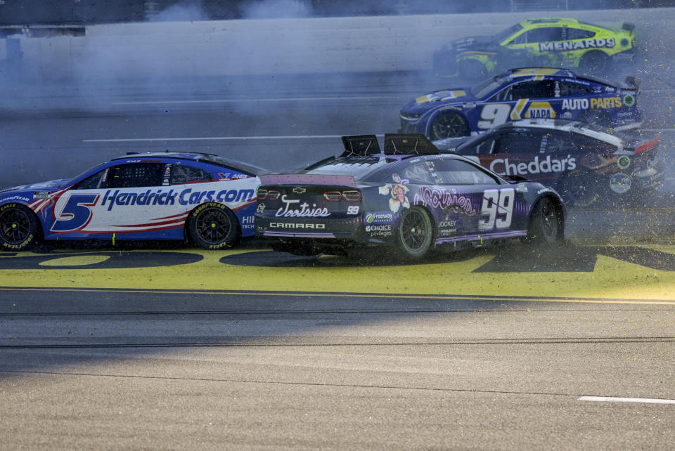 NASCAR Cup Series driver's Kyle Larson (5) and Daniel Suarez (99) collide during a collision on the final lap of a NASCAR Cup Series auto race at Talladega Superspeedway, Sunday, April 21, 2024, in Talladega. Ala. (AP Photo/Mike Stewart)