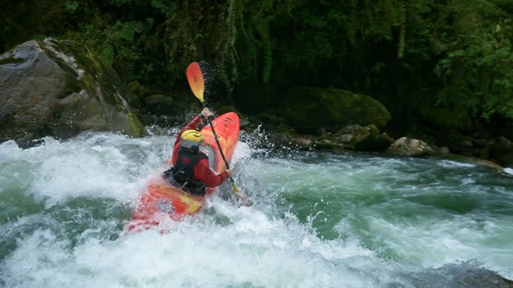 Kayaker paddling in whitewater\