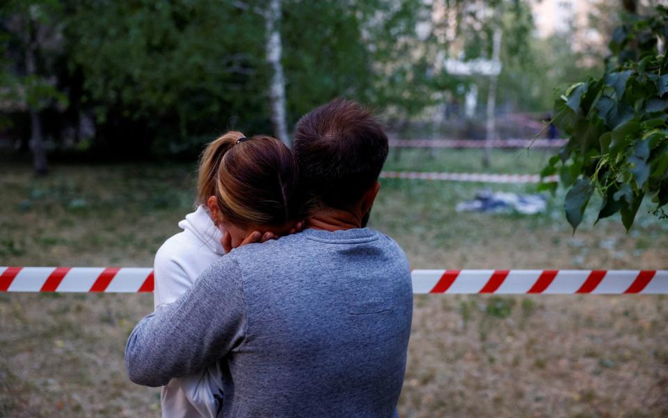 Residents react near the body of a person killed in a strike on Kyiv - VALENTYN OGIRENKO/REUTERS