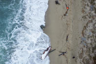 A view of part of the wreckage of a capsized boat that was washed ashore at a beach near Cutro, southern Italy, Monday, Feb. 27, 2023. Rescue crews searched by sea and air Monday for the dozens of people believed still missing from a shipwreck off Italy’s southern coast that drove home once again the desperate and dangerous crossings of migrants seeking to reach Europe. (AP Photo/Luigi Navarra)