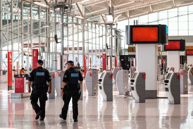 Police walk through an empty Sydney Airport.