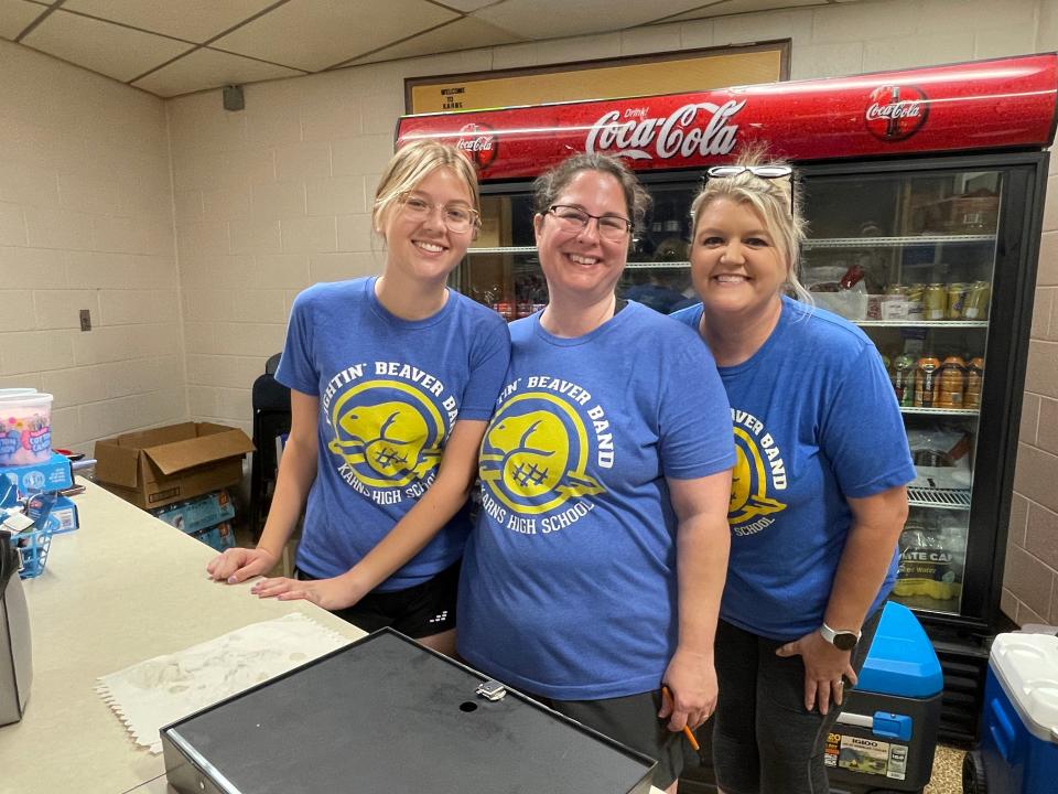 Band Boosters Avery Hanson, Sharon Brown, and Bailey Hanson offer snacks from the concession stand at the 70th annual Karns Community Fair at Karns High School on July 15, 2023.