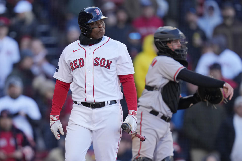 Boston Red Sox's Rafael Devers, left, heads back to the dugout after striking out during the ninth inning of the opening day baseball game against the Baltimore Orioles at Fenway Park, Thursday, March 30, 2023, in Boston. (AP Photo/Charles Krupa)