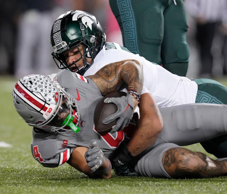 Nov. 11, 2023; Columbus, Oh., USA; 
Ohio State Buckeyes wide receiver Julian Fleming (4) is tackled by Michigan State Spartans linebacker Aaron Brule (7) during the first half of Saturday's NCAA Division I football game against the Michigan State Spartans.