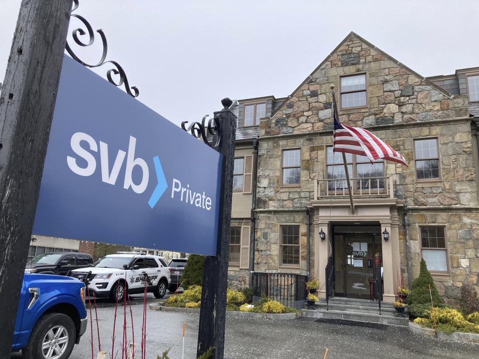 Vehicles are parked outside a Silicon Valley Bank branch in Wellesley, Mass., on Saturday, March 11, 2023. Regulators have seized the assets of one of Silicon Valley’s top banks, marking the largest failure of a U.S. financial institution since the height of the financial crisis almost 15 years ago. (AP Photo/Peter Morgan)