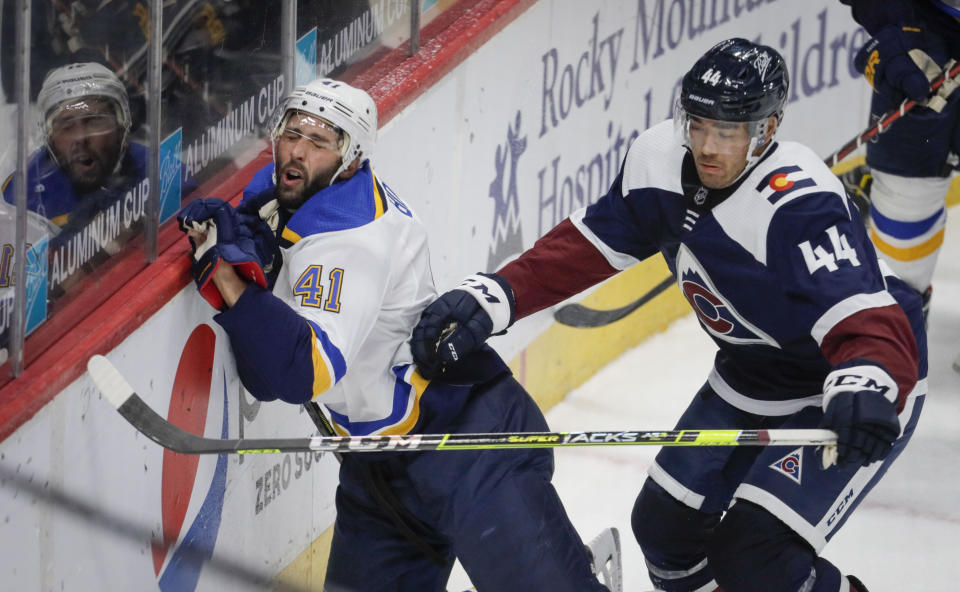 St. Louis Blues defenseman Robert Bortuzzo (41) hits the boards as Colorado Avalanche left wing Kiefer Sherwood (44) chases the puck in the third period of an NHL hockey game in Denver, Friday, April 2, 2021. (AP Photo/Joe Mahoney)