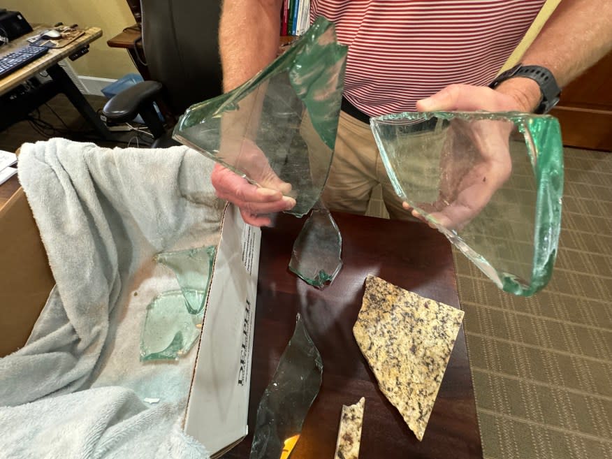 
		Attorney Sean Breen holds glass that was part of the St. David's North aquarium recovered from the vehicle that caused the crash. (KXAN Photo/Matt Grant)

        