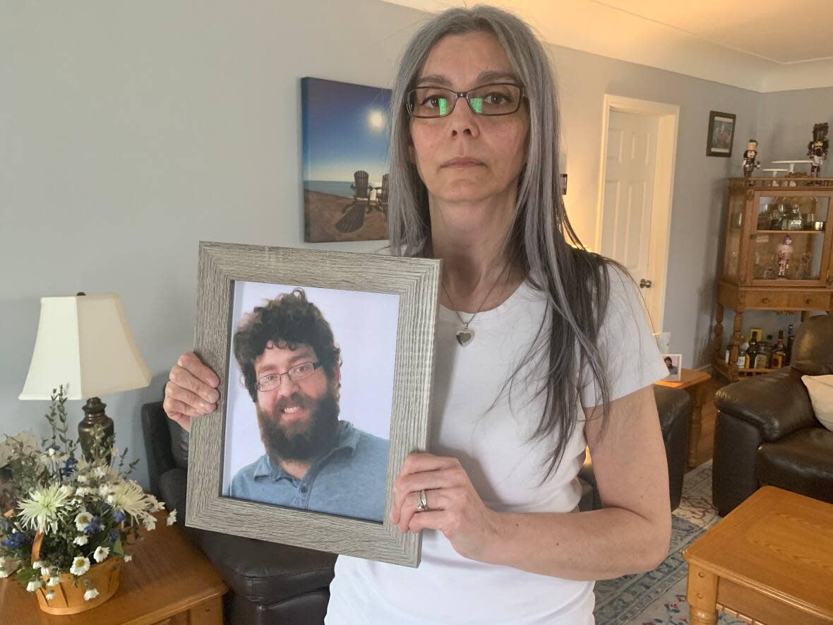 Leonie VanPuymbroeck holds a photo of her son, Robert Martin, in April. The Chatham, Ont., mom believes hospital officials could have done more to prevent the 26-year-old's death at the family home after he struggled with mental illness for years. (Katerina Georgieva/CBC - image credit)