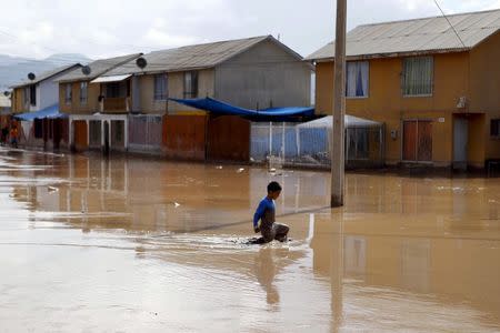 A child walks through a flooded street at Copiapo city, March 26, 2015. REUTERS/Ivan Alvarado