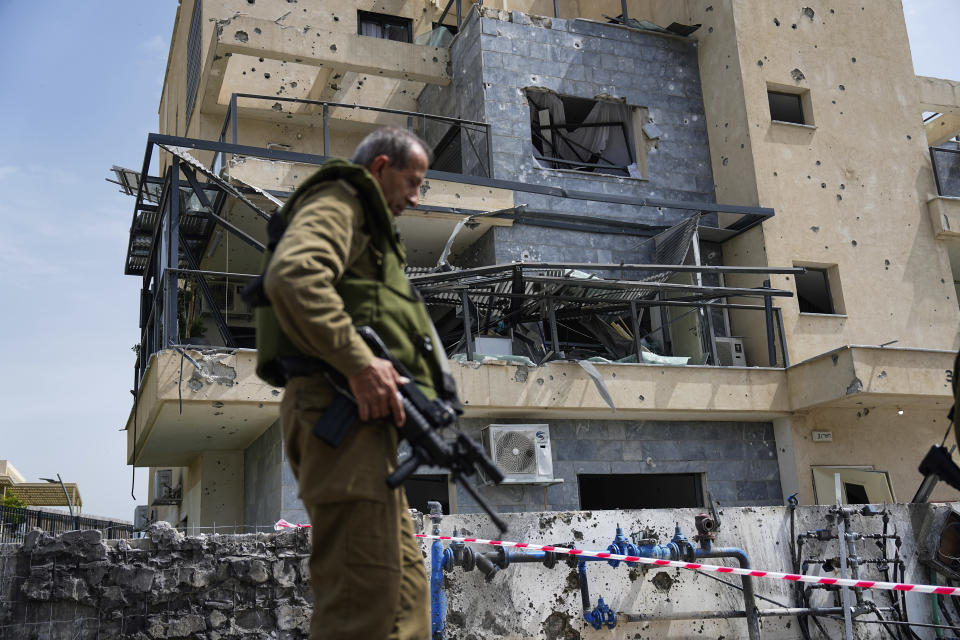 Israeli security forces examine the site hit by a rocket fired from Lebanon, in Kiryat Shmona, northern Israel, Wednesday, March 27, 2024. Israel Rescue Services said that one person was killed and two others lightly injured in a Hezbollah rocket attack on northern Israel. The man, aged 25, was killed from a fire that broke out at a factory in an industrial park in the northern city of Kiryat Shmona as a result of a direct hit. (AP Photo/Ariel Schalit)