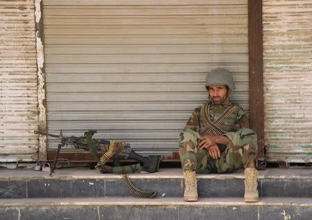 FILE PHOTO - An Afghan National Army (ANA) soldier sits in front of a closed shop in the downtown of Kunduz city, Afghanistan October 3, 2016.REUTERS/Nasir Wakif