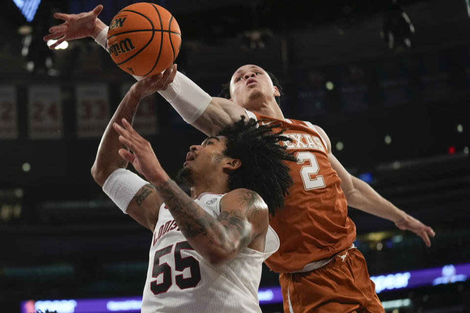 Louisville's Skyy Clark, left, puts up a shot as Texas's Chendall Weaver defends during the first half of an NCAA college basketball game, Sunday, Nov. 19, 2023, in New York. (AP Photo/Seth Wenig)