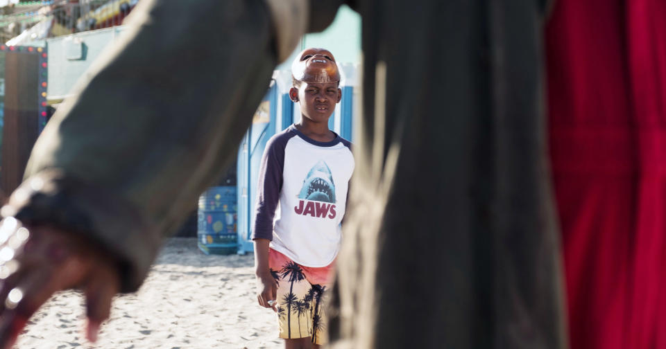 the kid wearing the T-shirt on the beach