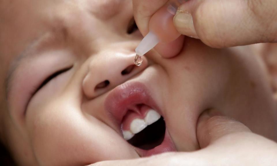 Health worker administers a vaccine to a baby at a local health center at the financial district of Makati, east of Manila