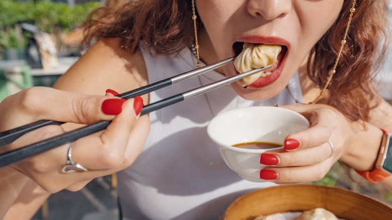 woman eating dumpling with black vinegar