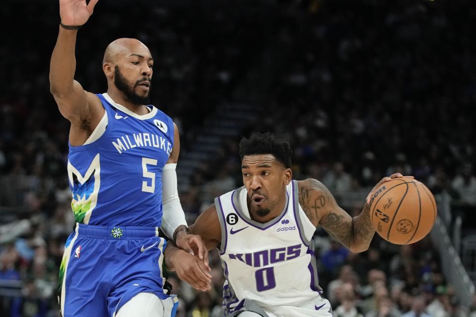 Sacramento Kings' Malik Monk drives past Milwaukee Bucks' Jevon Carter during the first half of an NBA basketball game Wednesday, Dec. 7, 2022, in Milwaukee. (AP Photo/Morry Gash)