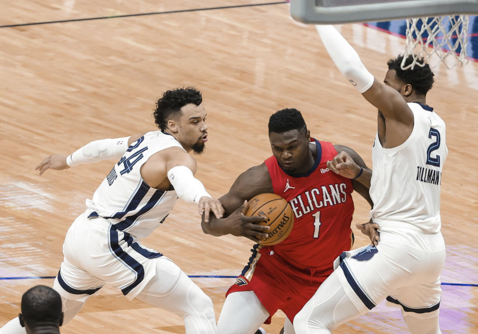 New Orleans Pelicans forward Zion Williamson (1) drives between Memphis Grizzlies guard Dillon Brooks (24) and forward Xavier Tillman (2) during the first quarter of an NBA basketball game in New Orleans, Saturday, Feb. 6, 2021. (AP Photo/Derick Hingle)