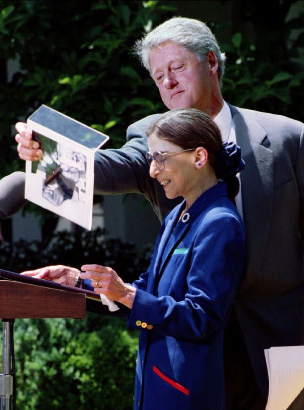 FILE PHOTO: President Clinton lifts a photo away during comments by Judge Ruth Bader Ginsburg after announcing J..