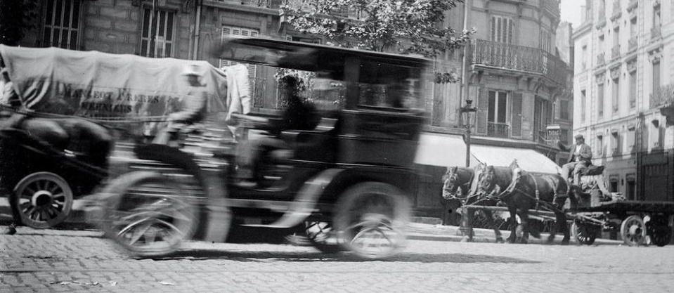 Au début du XXe siècle, les rares automobiles en circulation devaient partager la route avec des voitures hippomobiles et des chars à bœufs, comme ici à Paris en 1900.
