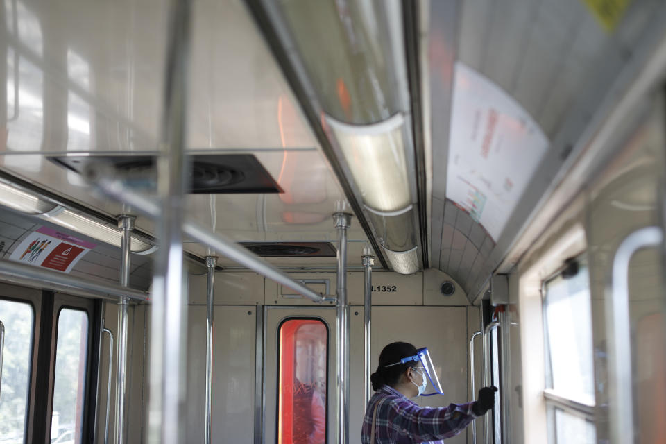 A commuter rides the Line 4 subway, several stations of which had been closed due to the coronavirus pandemic, as Mexico City expanded public transport options as part of the reopening process, Monday, June 15, 2020. Although the numbers of infected continue to rise, Mexican President Andres Manuel Lopez Obrador Monday urged citizens not to fear the virus and to start coming out of their homes to reactivate the economy.(AP Photo/Rebecca Blackwell)