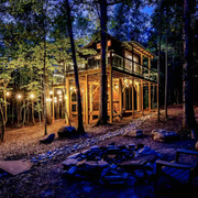 exterior of the treehouse lit up at night