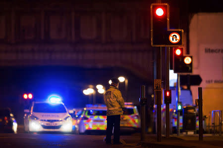 Police vehicles and a police officer are seen outside the Manchester Arena, where U.S. singer Ariana Grande had been performing in Manchester, northern England, Britain May 22, 2017. REUTERS/Jon Super