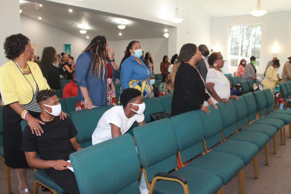 Parishioners stand during the Sunday morning worship service at DaySpring Baptist Church that celebrated the church's 108th anniversary.