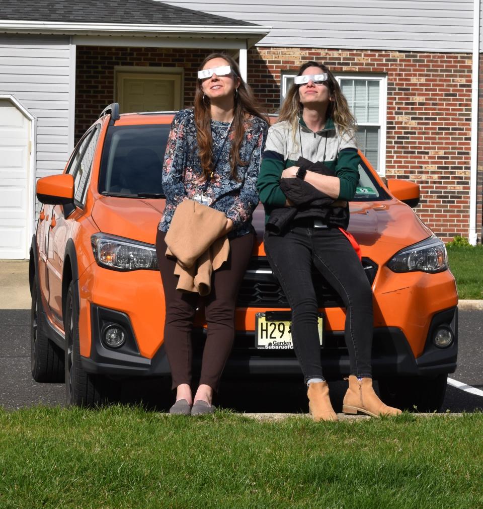 Maria Pinto, left, and Aliana Katz watch the fianl moments of the eclipse from West Tampa Avenue in Cherry Hill.