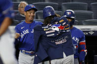 Toronto Blue Jays' Bo Bichette (11) is helped with the home run jacket by manager Charlie Montoyo after Bichette hit a home run against the New York Yankees during the first inning of a baseball game Thursday, Sept. 9, 2021, in New York. (AP Photo/Adam Hunger)