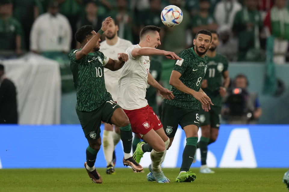 Poland's Arkadiusz Milik, center, heads the ball during the World Cup group C soccer match between Poland and Saudi Arabia, at the Education City Stadium in Al Rayyan, Qatar, Saturday, Nov. 26, 2022. (AP Photo/Aijaz Rahi)