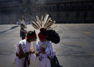 Dos jóvenes charlan antes de participar en la conmemoración del 700 aniversario de la fundación de la ciudad azteca de Tenochtitlan, hoy conocida como Ciudad de México, en la Plaza del Zócalo, en la Ciudad de México, el 26 de julio de 2021, en plena pandemia del coronavirus. (AP Foto/Fernando Llano)