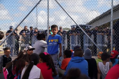 A group of migrants who returned to Mexico to await their U.S. asylum hearing block the Puerta Mexico international border crossing bridge