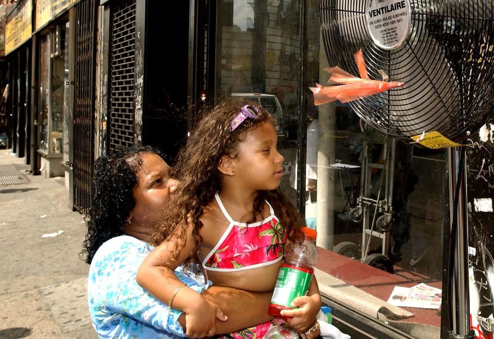A street fan provides relief on a hot summer day in New York City. <a href="https://www.gettyimages.com/detail/news-photo/nala-pabong-holds-her-daughter-nala-fonseca-up-to-a-fan-to-news-photo/1194893" rel="nofollow noopener" target="_blank" data-ylk="slk:Stephen Chernin/Getty Images;elm:context_link;itc:0;sec:content-canvas" class="link ">Stephen Chernin/Getty Images</a>