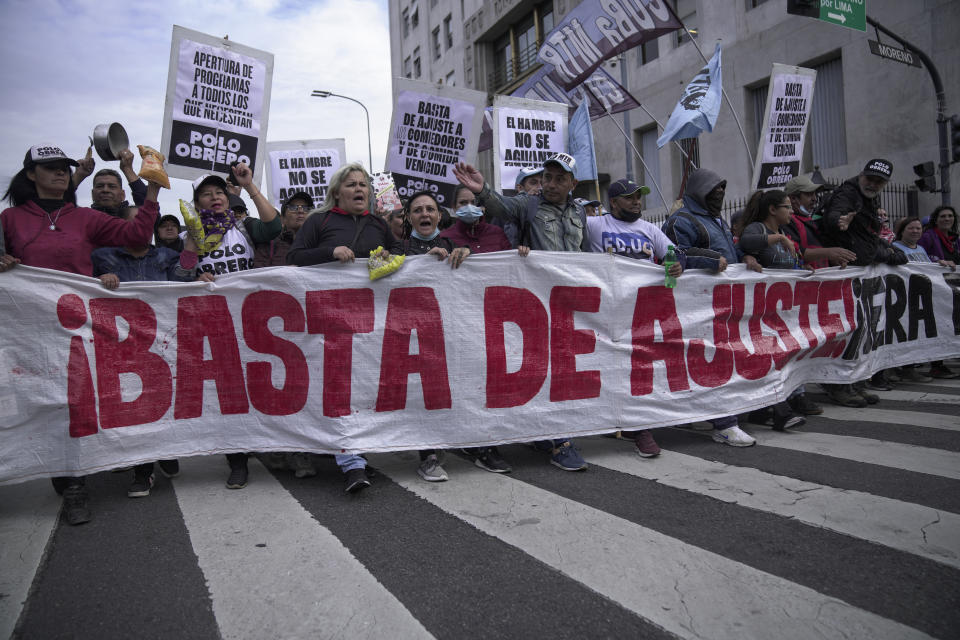 People march with a banner that reads in Spanish "Stop the adjustment, out with the IMF," outside the Social Development Ministry in Buenos Aires, Argentina, Tuesday, May 9, 2023. Members of social organizations protested government policies and demanded higher salaries amid high inflation. (AP Photo/Victor R. Caivano)
