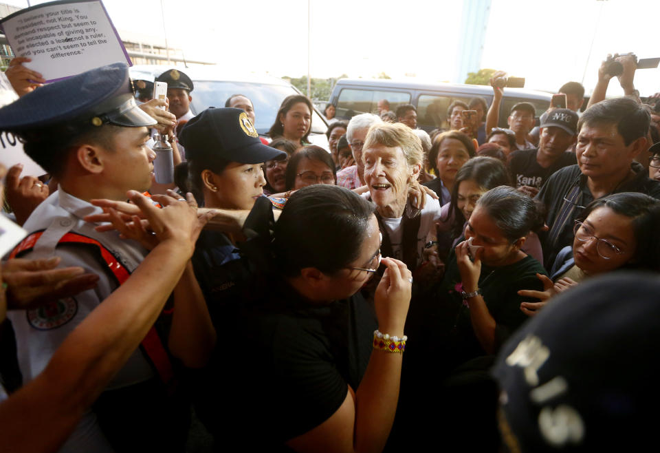 Australian Roman Catholic nun Sister Patricia Fox reaches out to bid goodbye to supporters as she is escorted to the Ninoy Aquino International Airport for her flight to Australia Saturday, Nov. 3, 2018, in Manila, Philippines. Sister Fox decided to leave after 27 years in the country after the Immigration Bureau denied her application for the extension of her visa. Sr. Fox called on Filipinos to unite and fight human rights abuses ahead of her forced departure from the country. (AP Photo/Bullit Marquez)