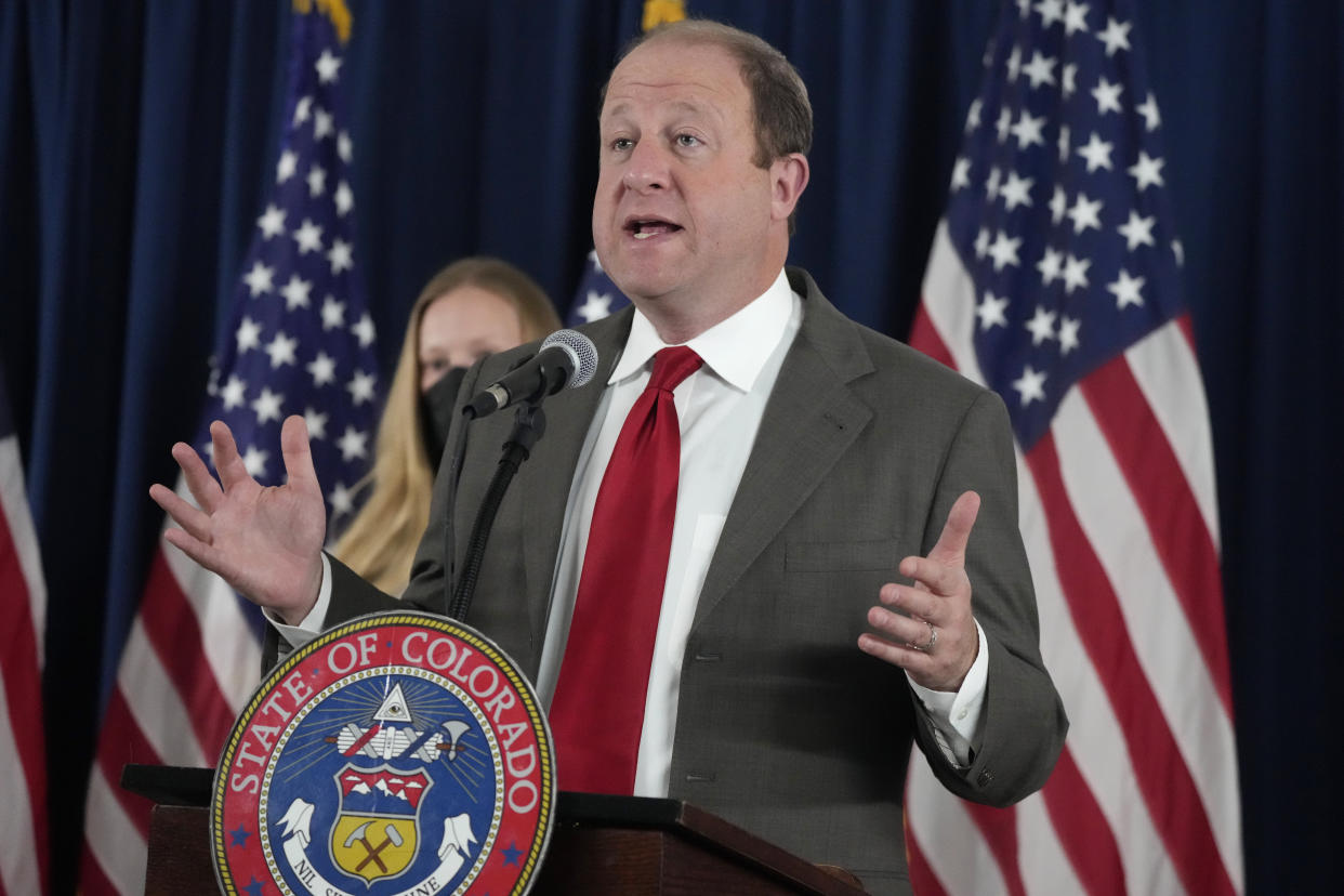 Colorado Governor Jared Polis gestures during a news conference on the state's response to the COVID-19 pandemic.