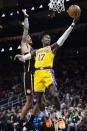 Los Angeles Lakers guard Dennis Schroder scores next to Atlanta Hawks forward John Collins during the first half of an NBA basketball game Friday, Dec. 30, 2022, in Atlanta. (AP Photo/Hakim Wright Sr.)