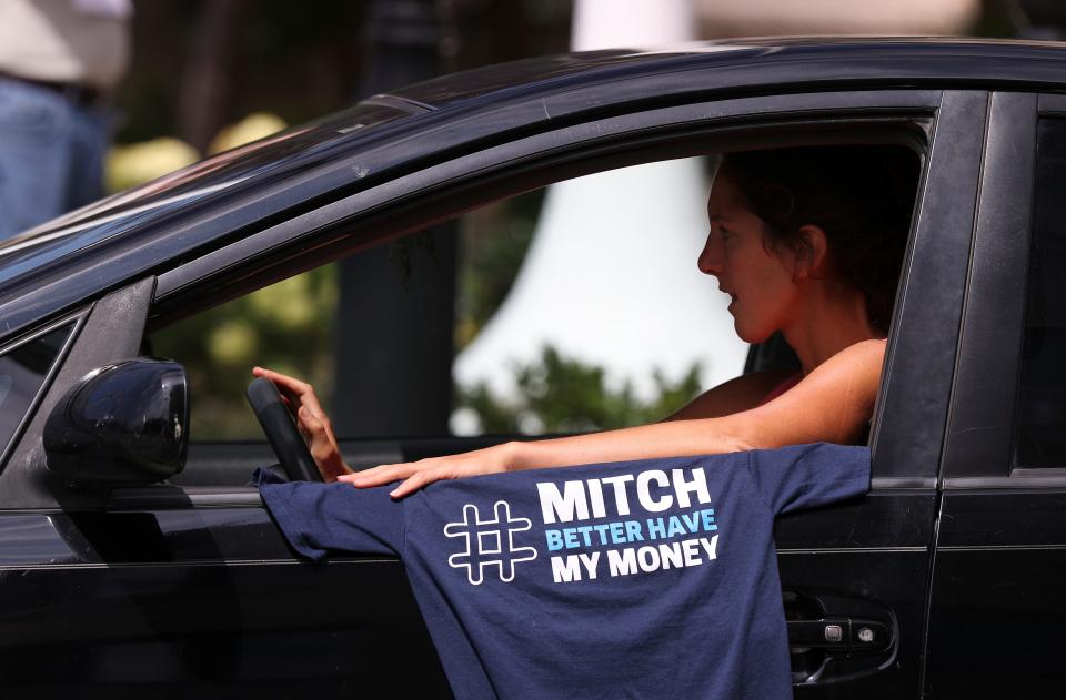 A car caravan drove past the federal courthouse to demand that Sen. Mitch McConnell reinstate unemployment benefits.
