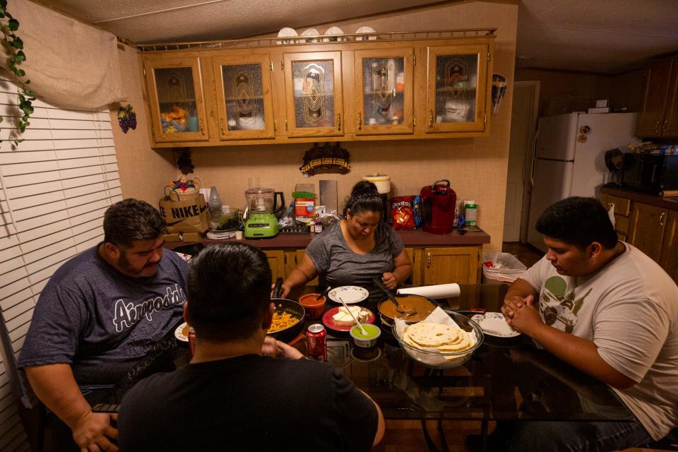 The Medina family prays before a meal at their home in Lake Dallas, Texas. Two sons are protected under DACA while their mother, father and brother could be deported for living in the U.S. illegally.