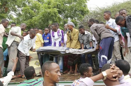 Residents bury the dead body of Mohamed Abdikarim, a Somali journalist for the London-based Universal TV channel, who was killed during a suicide car bomb attack at the Jazeera hotel in Somalia's capital Mogadishu, July 27, 2015. REUTERS/Feisal Omar