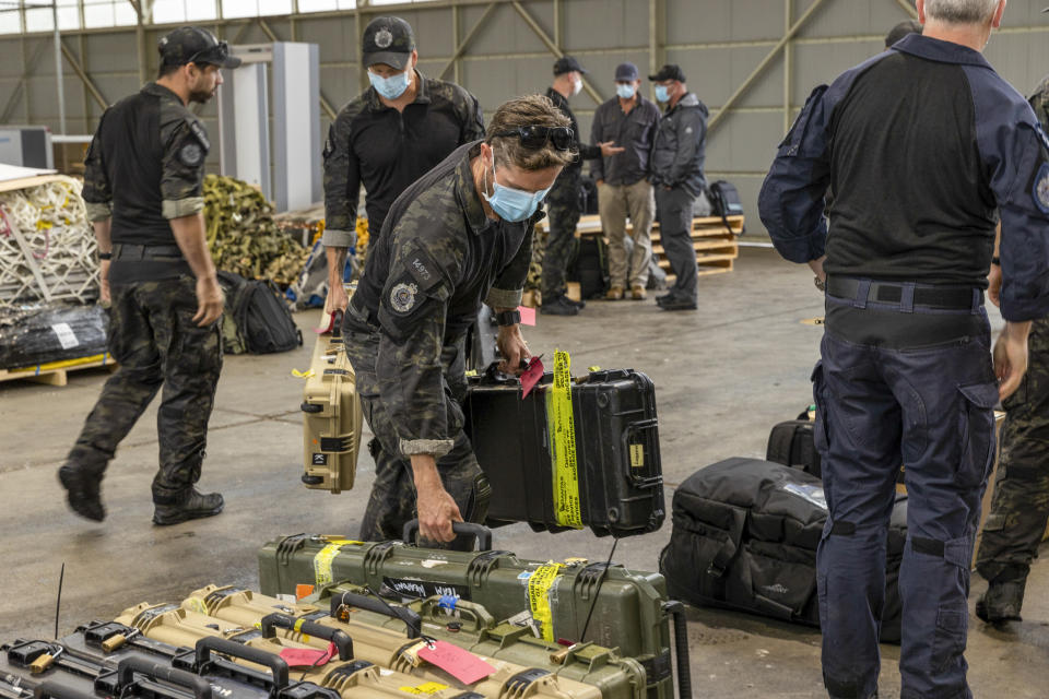 In this photo released by Australian Department of Defense, Australian Federal Police Special Operations members prepare to depart Canberra, Australia, for the Solomon Islands Thursday, Nov. 25, 2021. Australia says it is sending police, troops and diplomats to the Solomon Islands to help after anti-government demonstrators defied lockdown orders and took to the streets for a second day in violent protests. (LACW Jacqueline Forrester/Australian Department of Defense via AP)