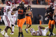 Oklahoma State defensive end Tyler Lacy (89) celebrates after a tackle of Oklahoma running back Kennedy Brooks (26) during the first half of an NCAA college football game Saturday, Nov. 27, 2021, in Stillwater, Okla. (AP Photo/Sue Ogrocki)